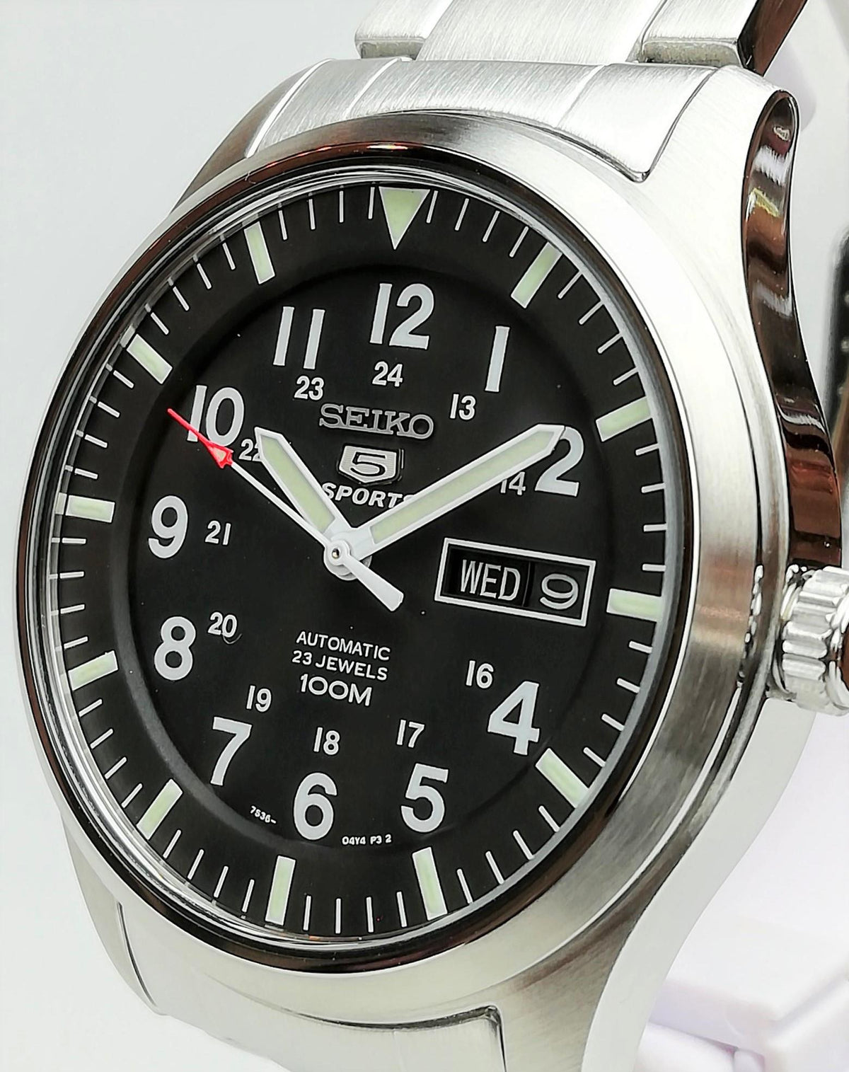 Men's Seiko 5 Sports watch closeup: black dial with day-date window and steel side