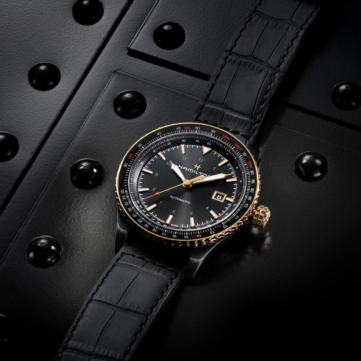 Men's automatic watch on black leather strap, black dial with subsecond markers and crown.