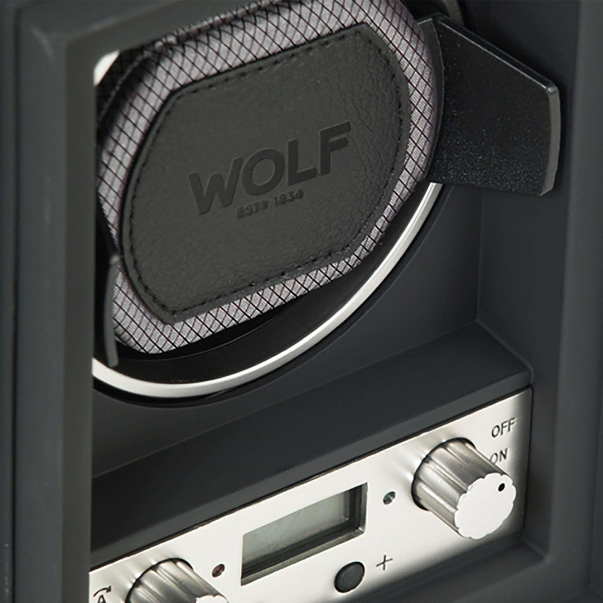 Close view of WOLF logo on black watch winder cushion with chrome ring and mesh