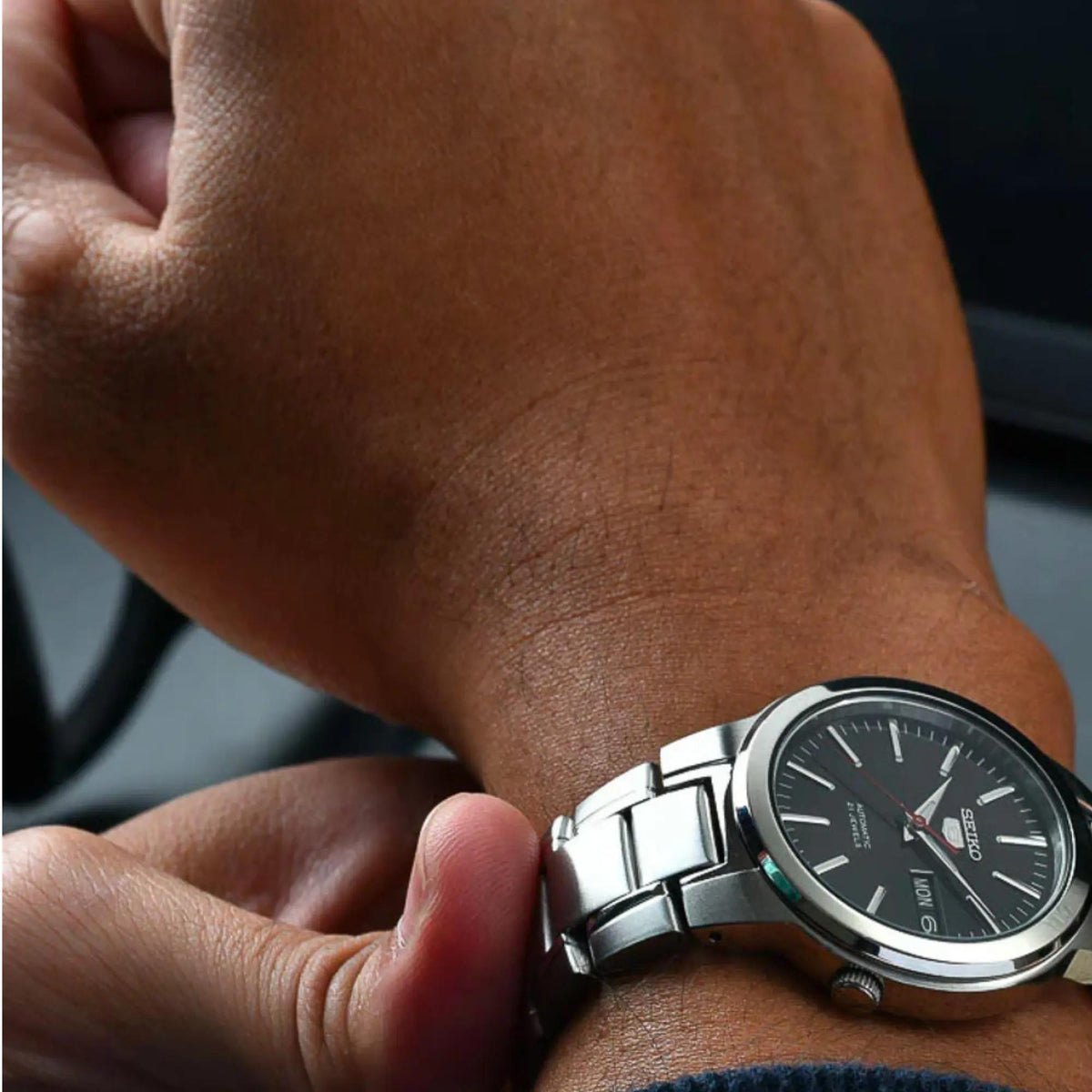 Seiko automatic men's watch on wrist, black dial with red seconds hand and metal bracelet