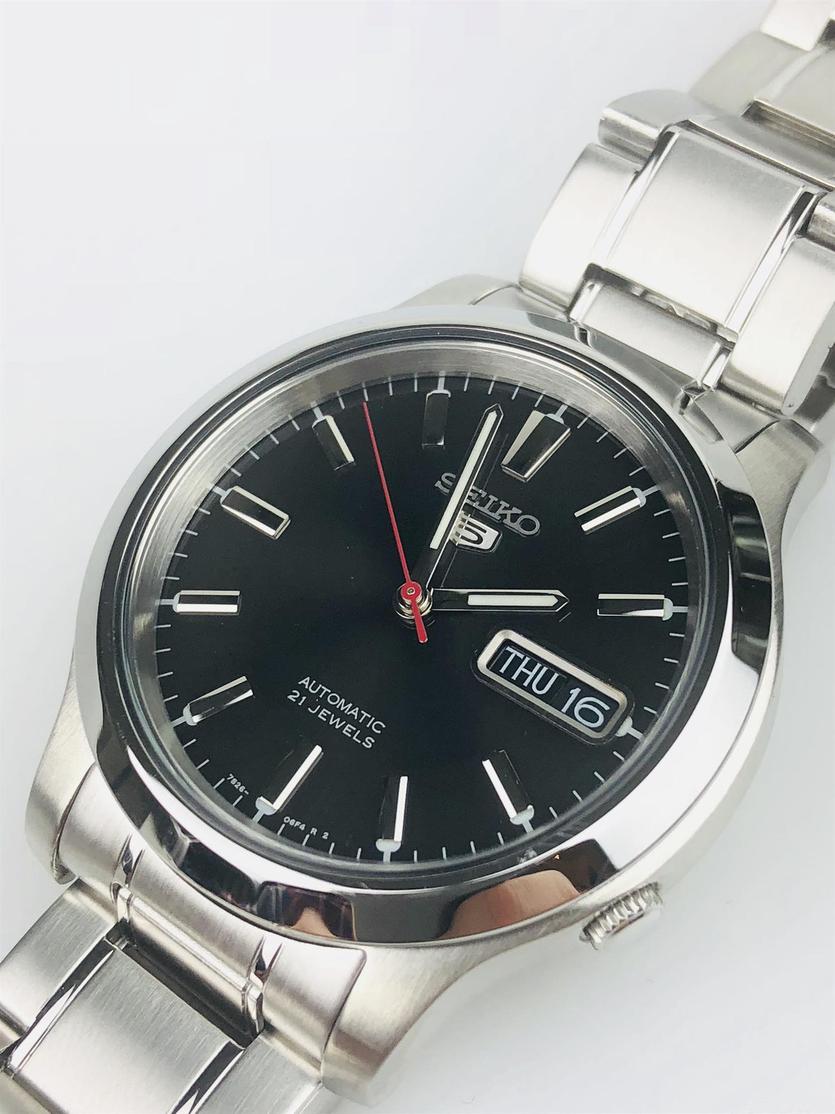 Seiko automatic watch with black dial, silver markers, red seconds hand, day window
