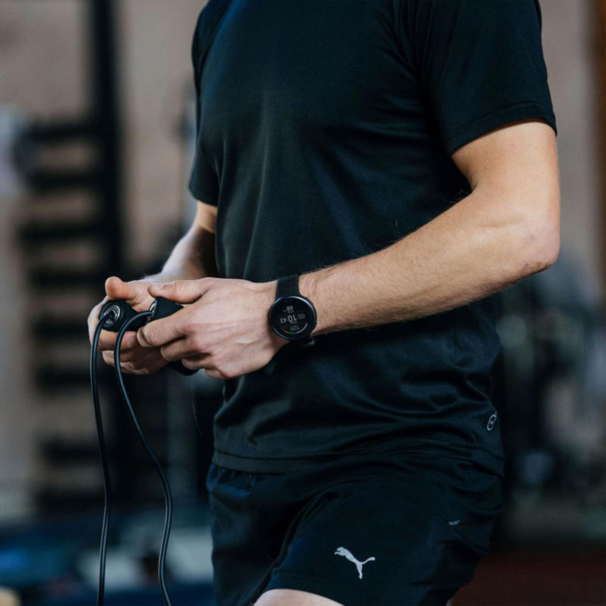 Black rubber-strap smartwatch on arm, round dark display visible