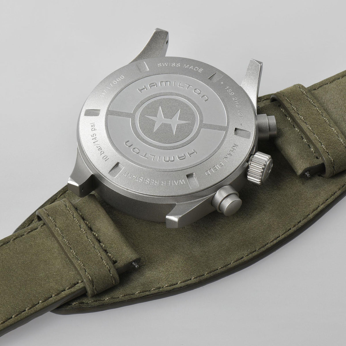 Hamilton automatic watch back with star logo on silver case, olive leather strap