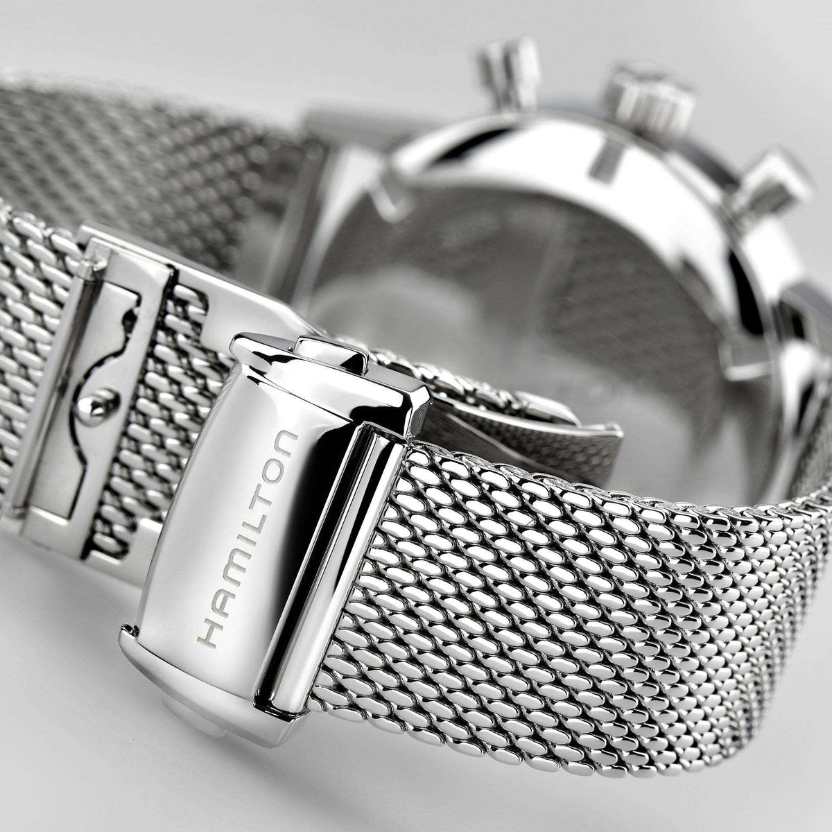 Stainless steel watch bracelet clasp with black dial chronograph case close-up