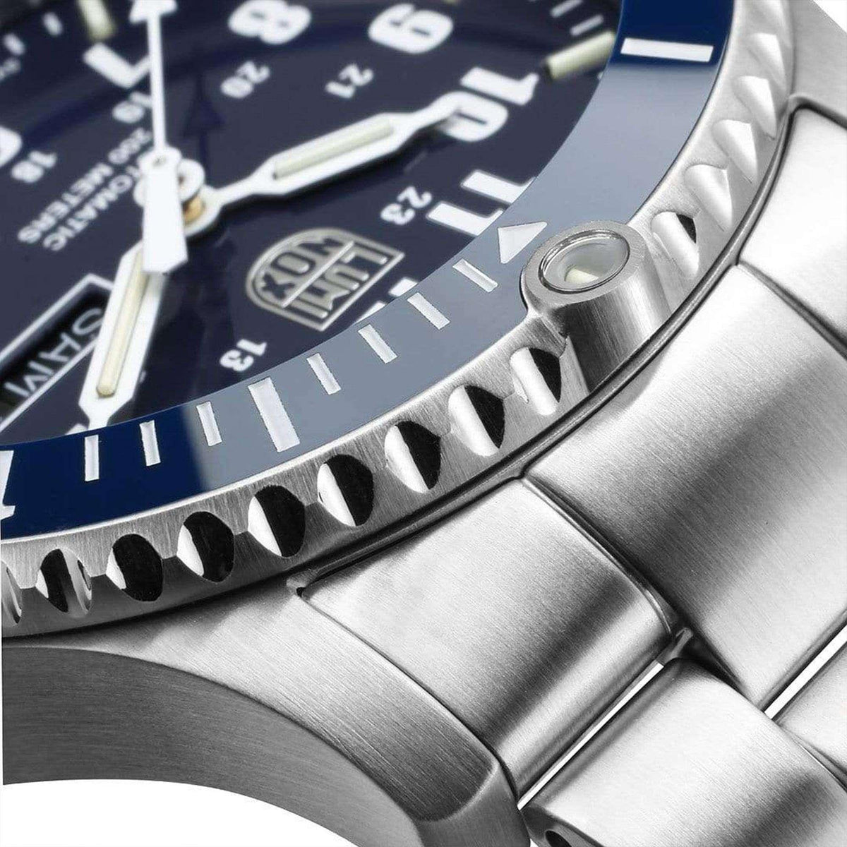 Men's stainless steel watch bezel and bracelet link close-up over dark blue dial