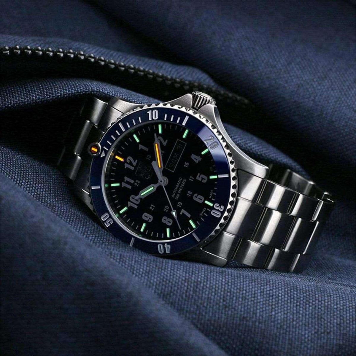 Men's stainless steel watch with dark blue dial and luminous markers on fabric