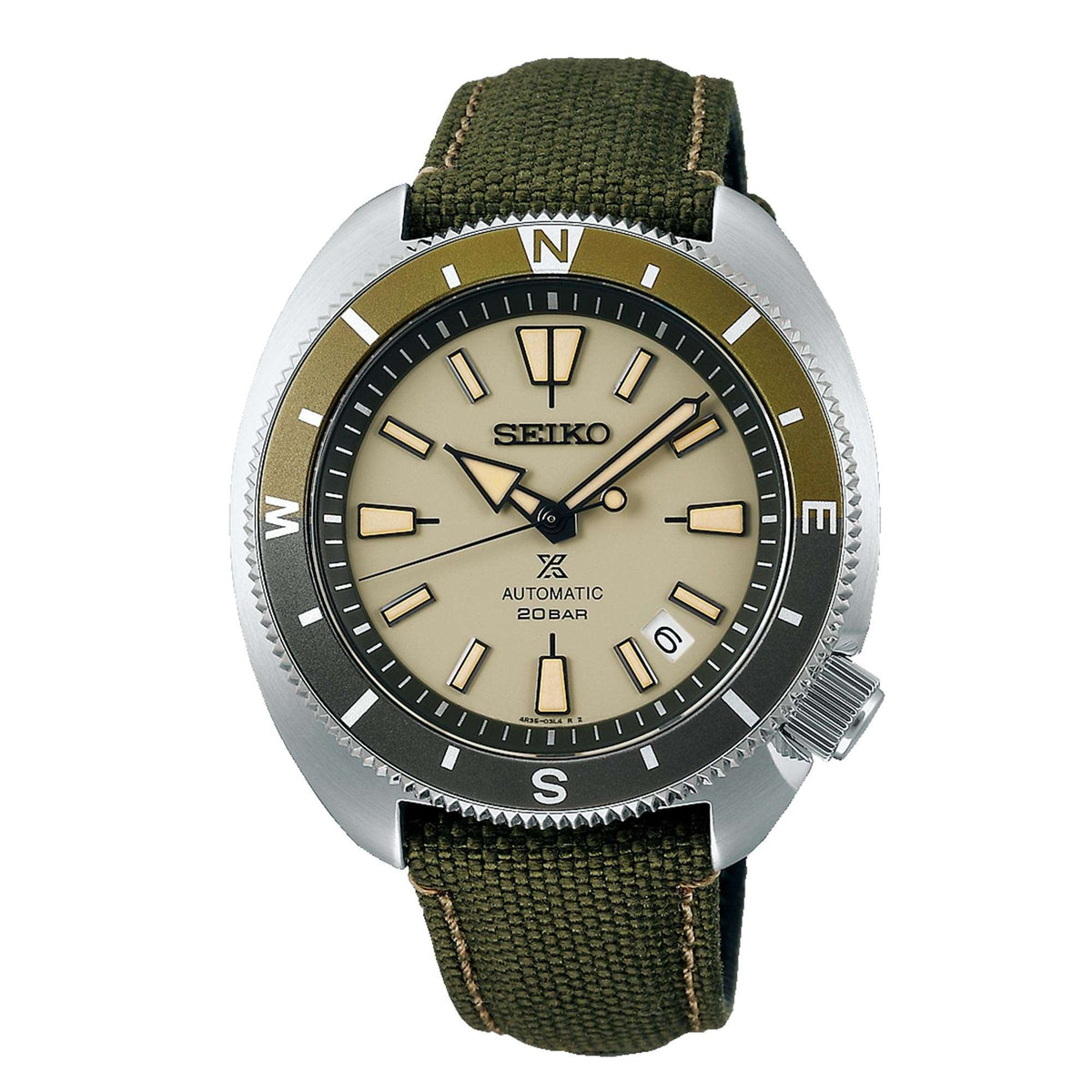 Men's automatic watch close-up with tan dial, green canvas strap, silver case bezel