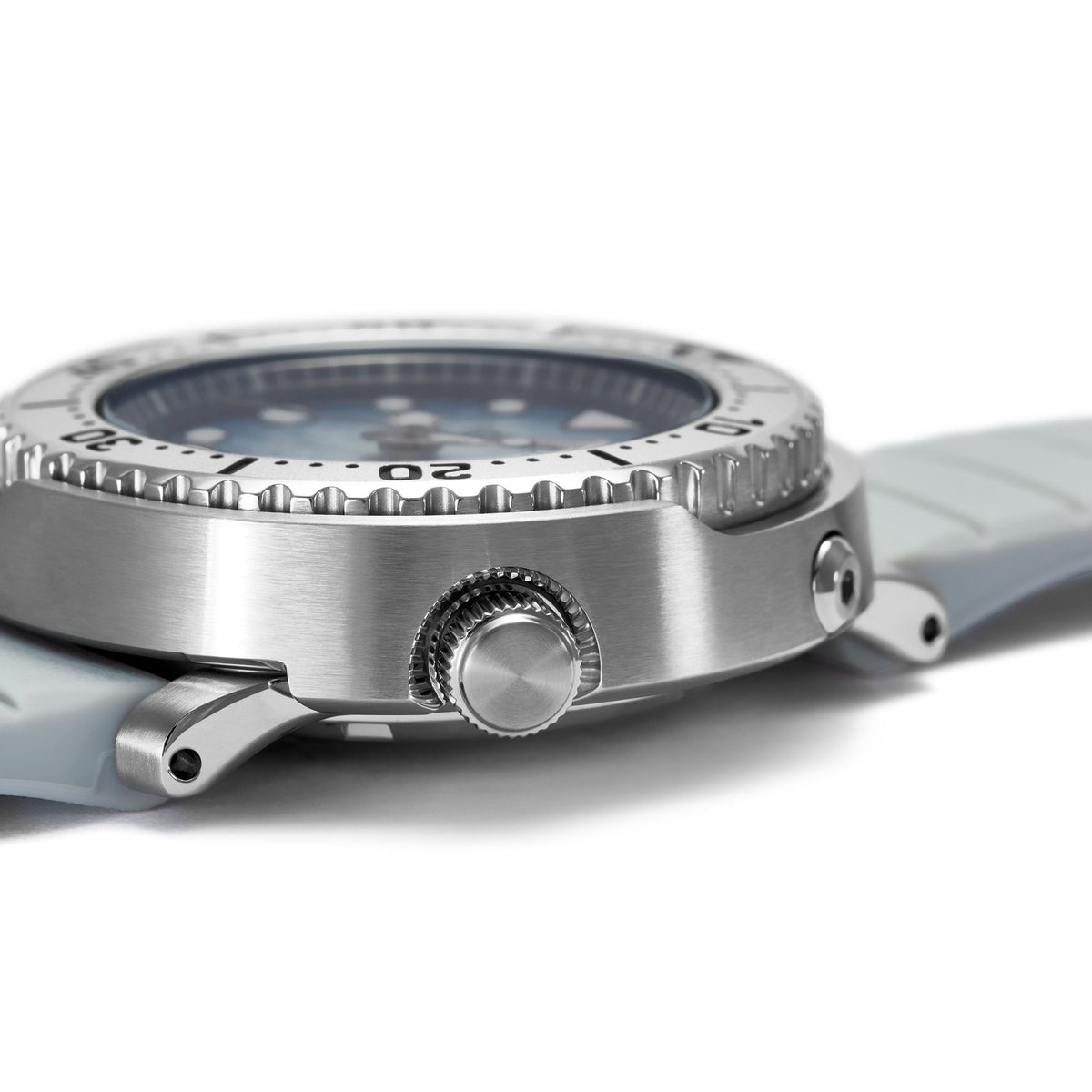 Men's dive watch case profile with crown, steel detailing, and light gray silicone strap
