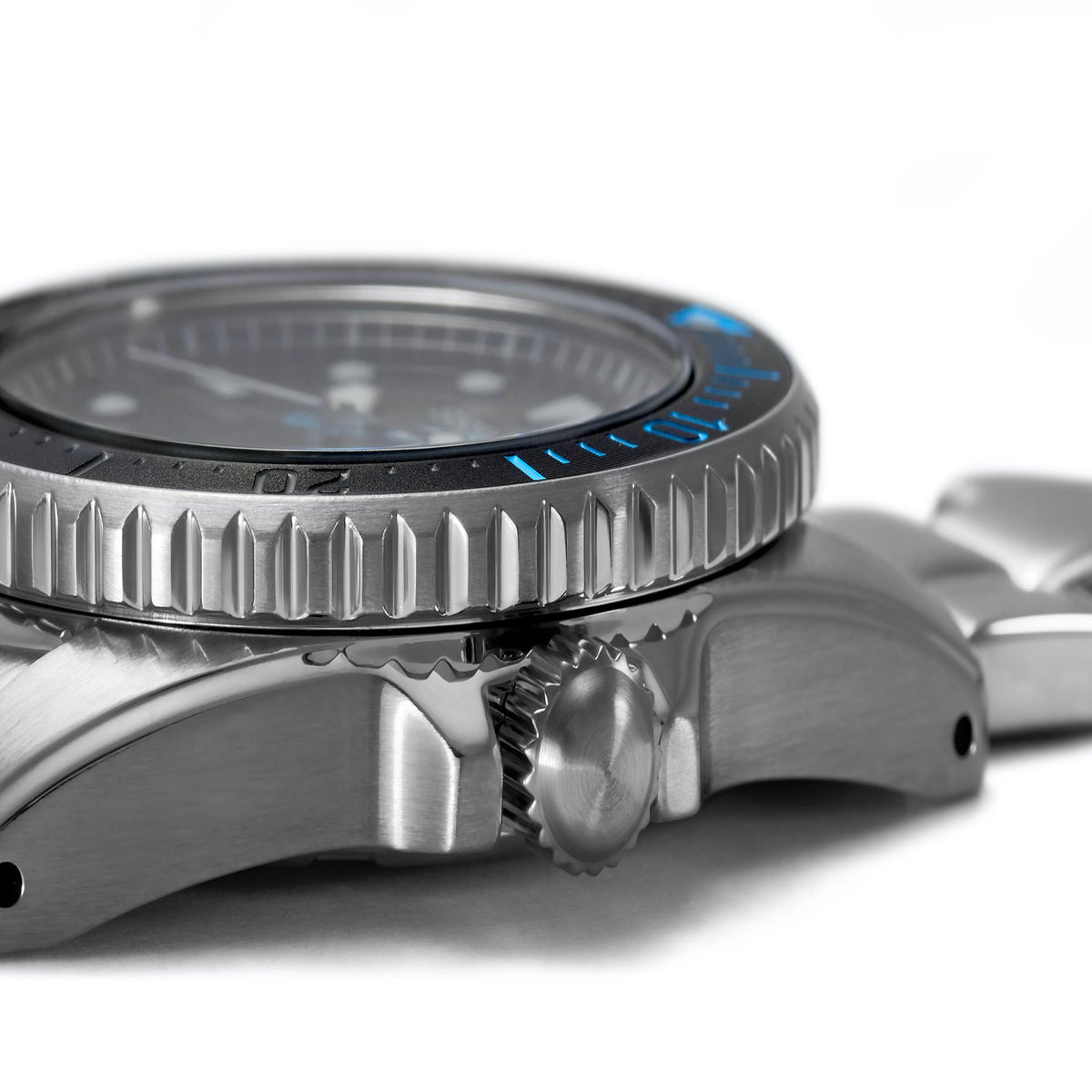 Close-up stainless steel case side with ridged bezel and crown