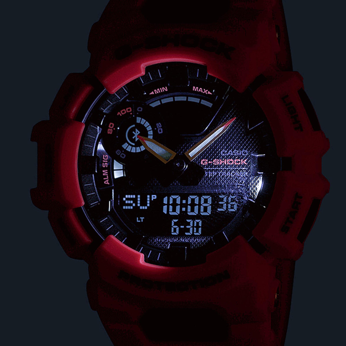 Casio G-Shock digital analog watch with black dial and red resin strap, close-up.