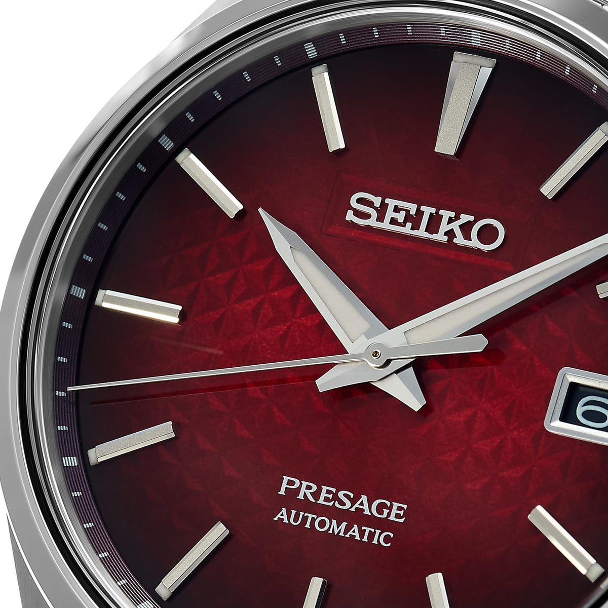 Red patterned automatic watch dial with Seiko text, silver hands, and date window detail