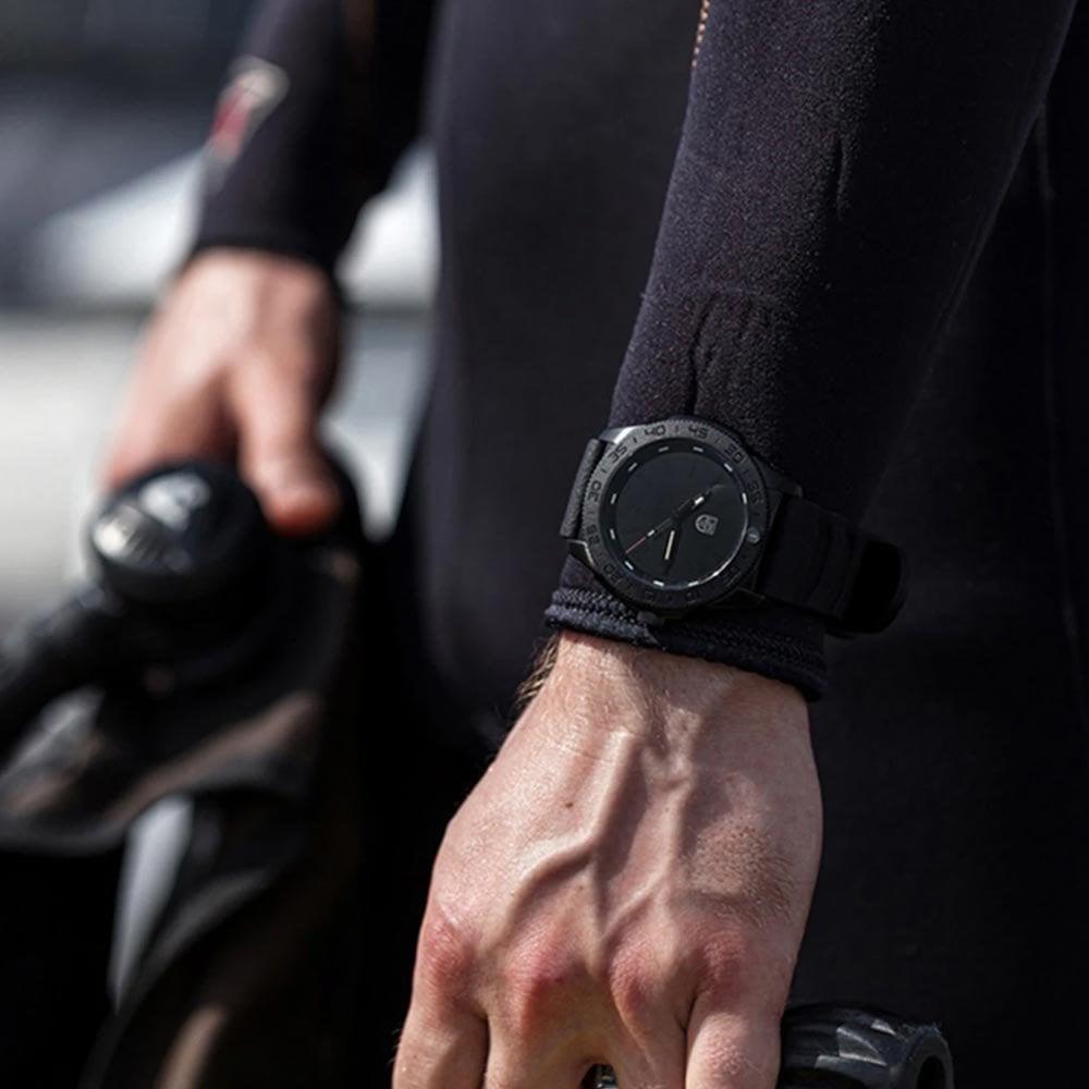 Men's black diver watch on black rubber strap, round black dial with green accents