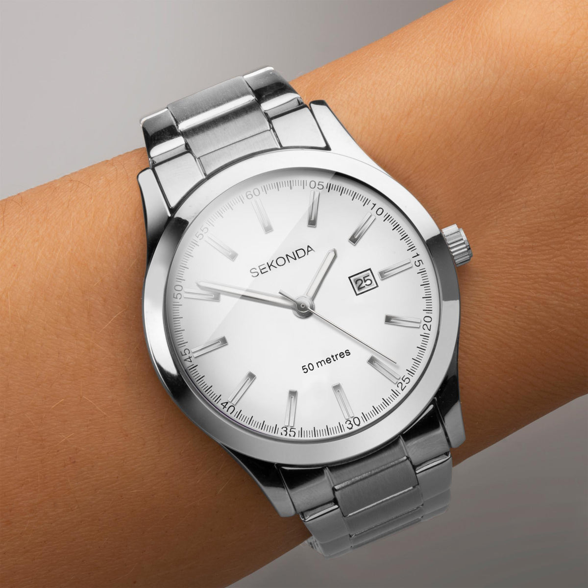 Ladies stainless steel watch on wrist, white dial with date 25 and marker hands