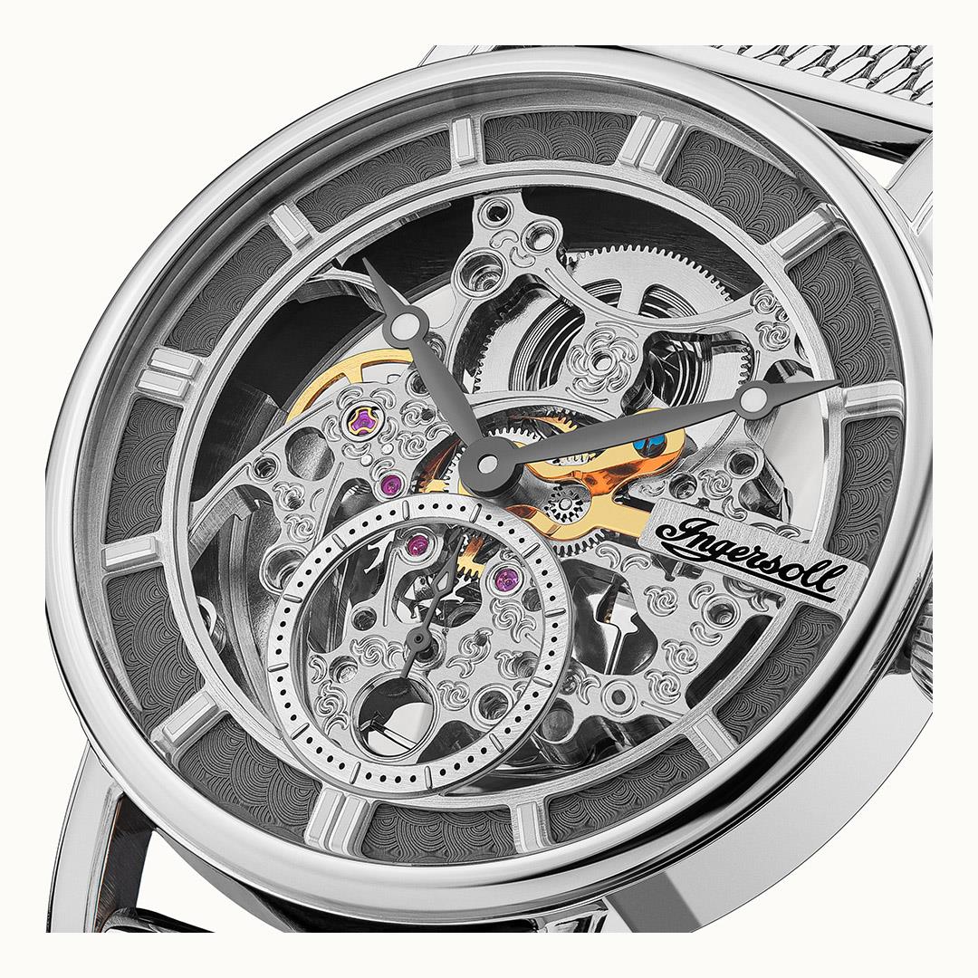 Detailed view of men's automatic skeleton movement on grey dial, silver bezel.