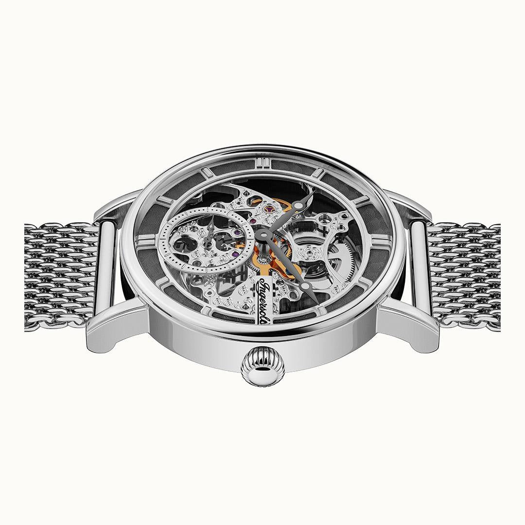 Men's automatic skeleton watch angled view with visible movement and silver mesh bracelet.
