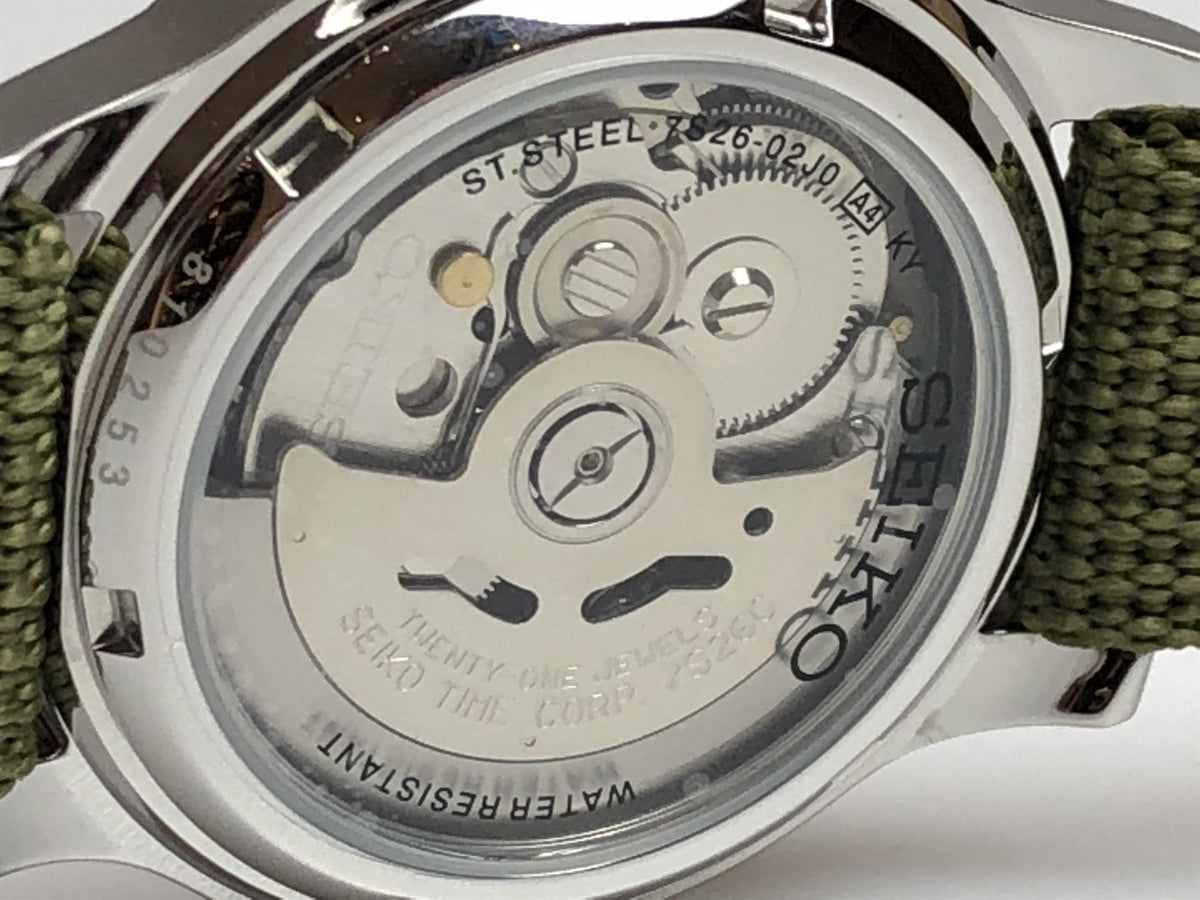 Automatic wristwatch with stainless steel caseback and visible gears; green fabric strap