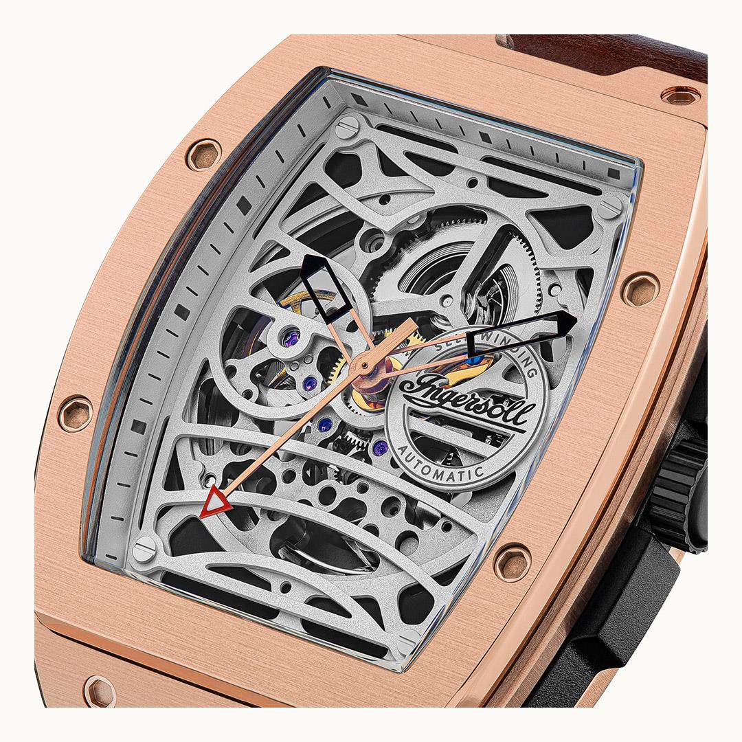 Angled close-up of rose-gold skeleton dial showing gears through glass and strap.