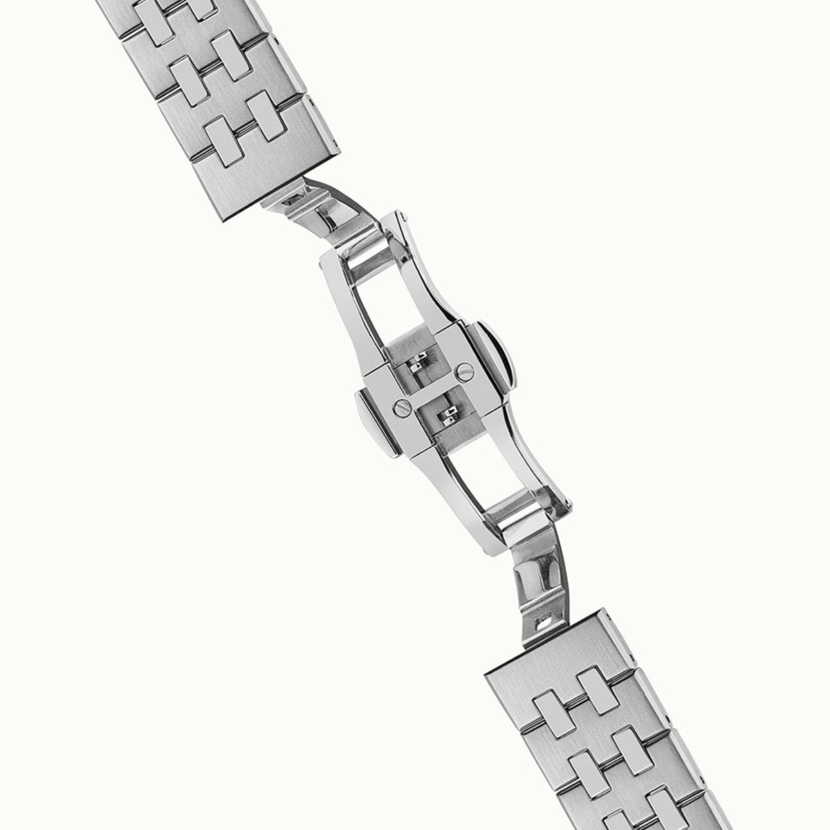 Stainless steel bracelet and clasp detail with polished links on a round automatic watch case