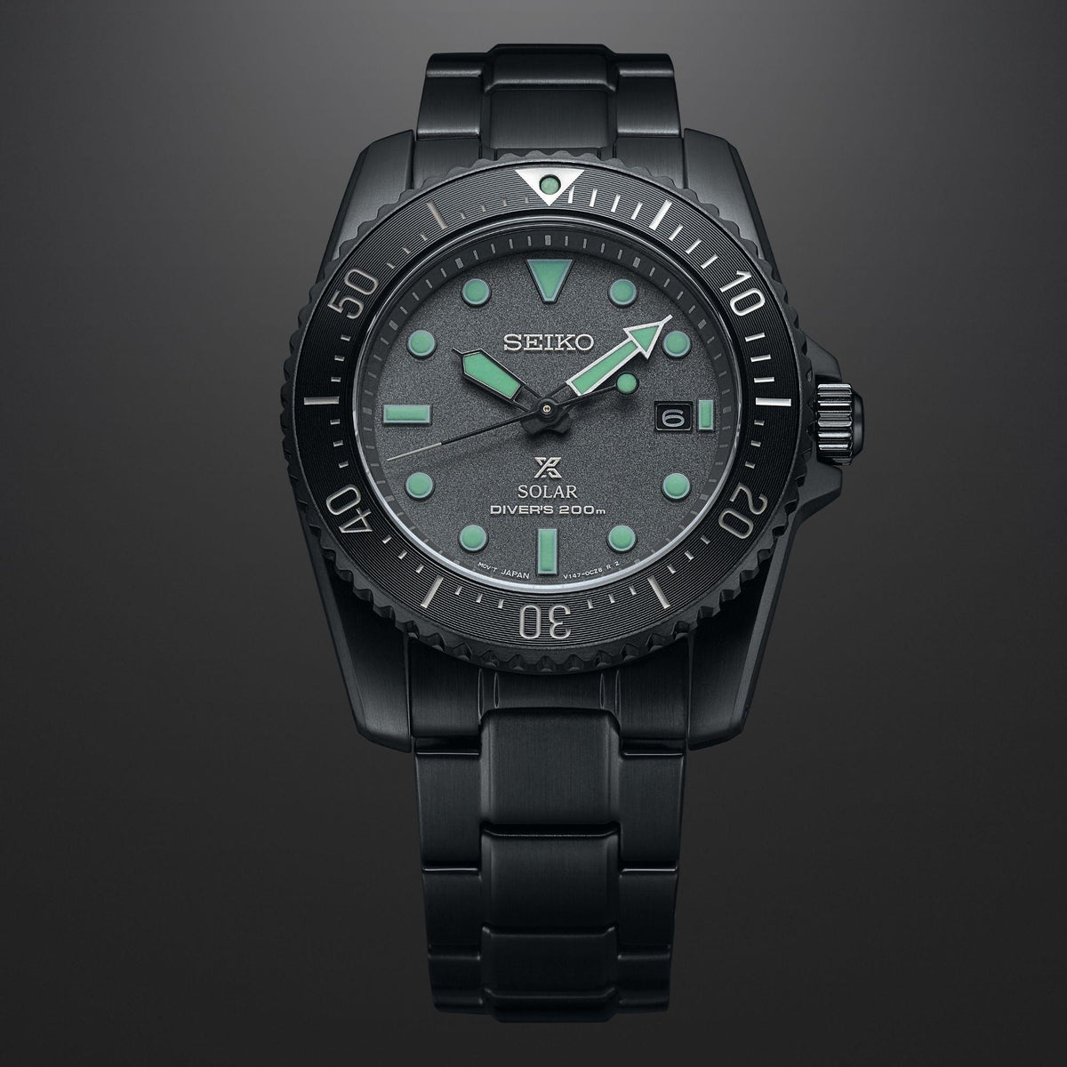 Black solar dive watch with green-accent dial and black metal bracelet