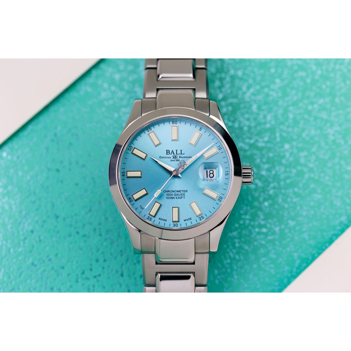 Stainless steel round watch with ice blue dial and date window, bracelet extending outward