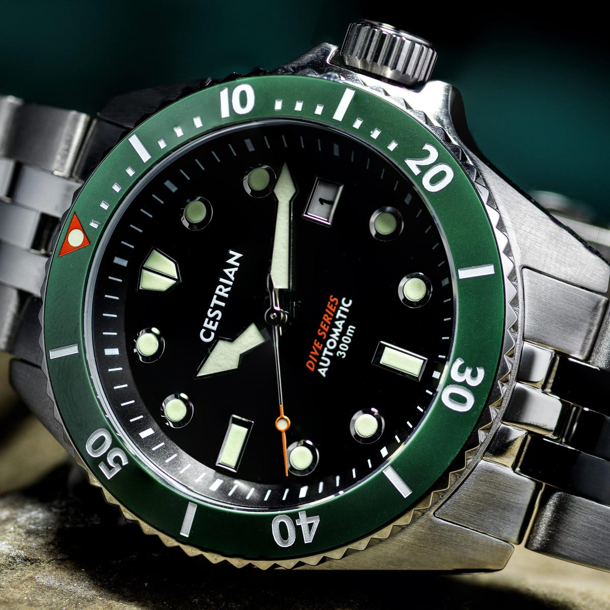 Men's automatic dive watch with green bezel, black dial markers, steel bracelet