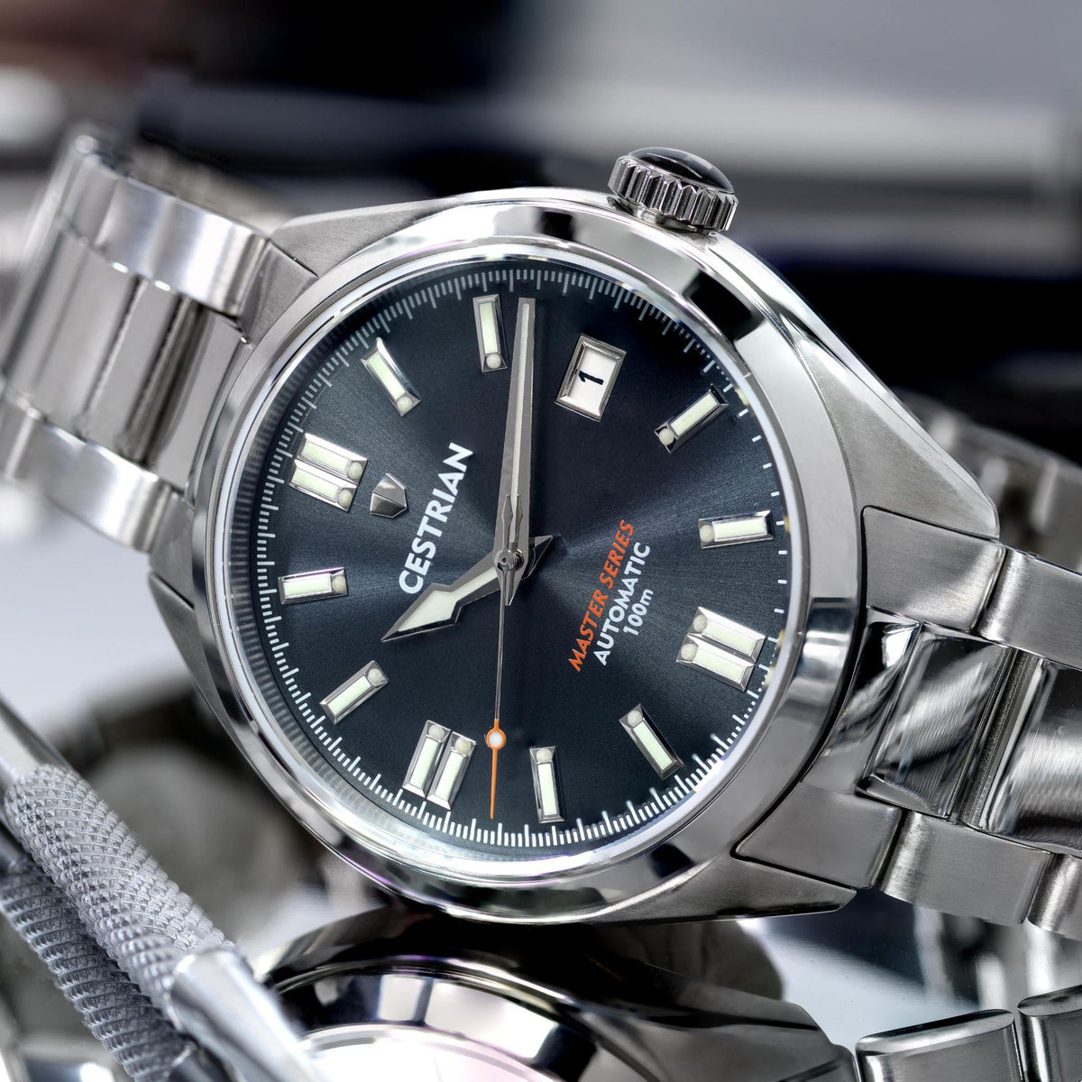 Automatic men's watch close-up: dark dial, steel case, and luminous time markers