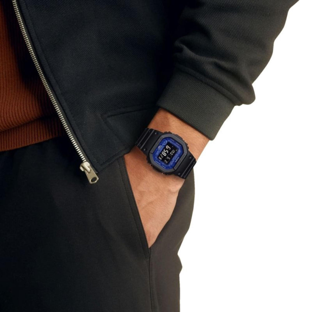 Casio G-Shock radio-controlled watch worn on wrist, blue digital face with dark resin strap