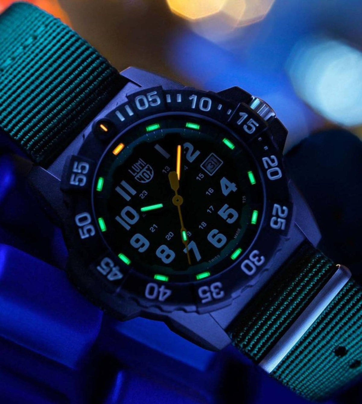 Men's military-style wrist watch with green glowing markers, dark dial, fabric strap