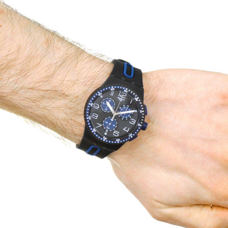 Men's black dial chronograph watch with blue subdials on wrist, rubber strap