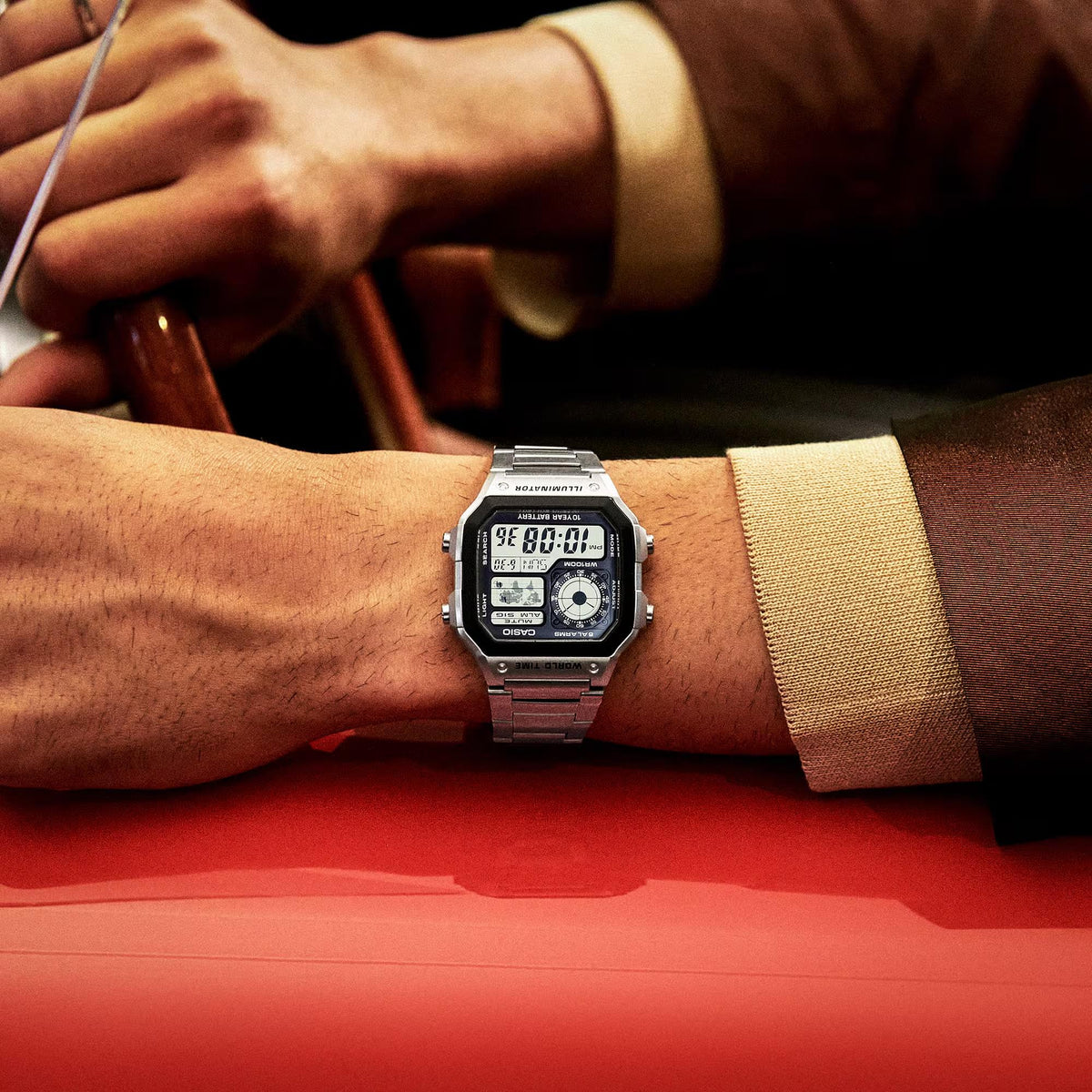 Men's Casio world time watch on wrist with silver steel bracelet and dark digital display