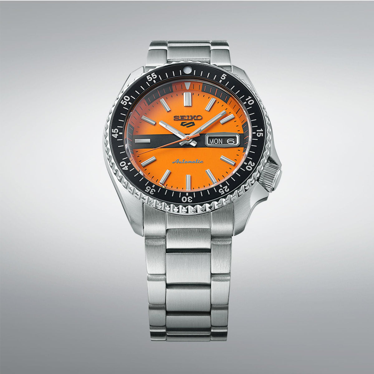 Seiko sports watch side angle, orange dial with date window, steel bracelet.