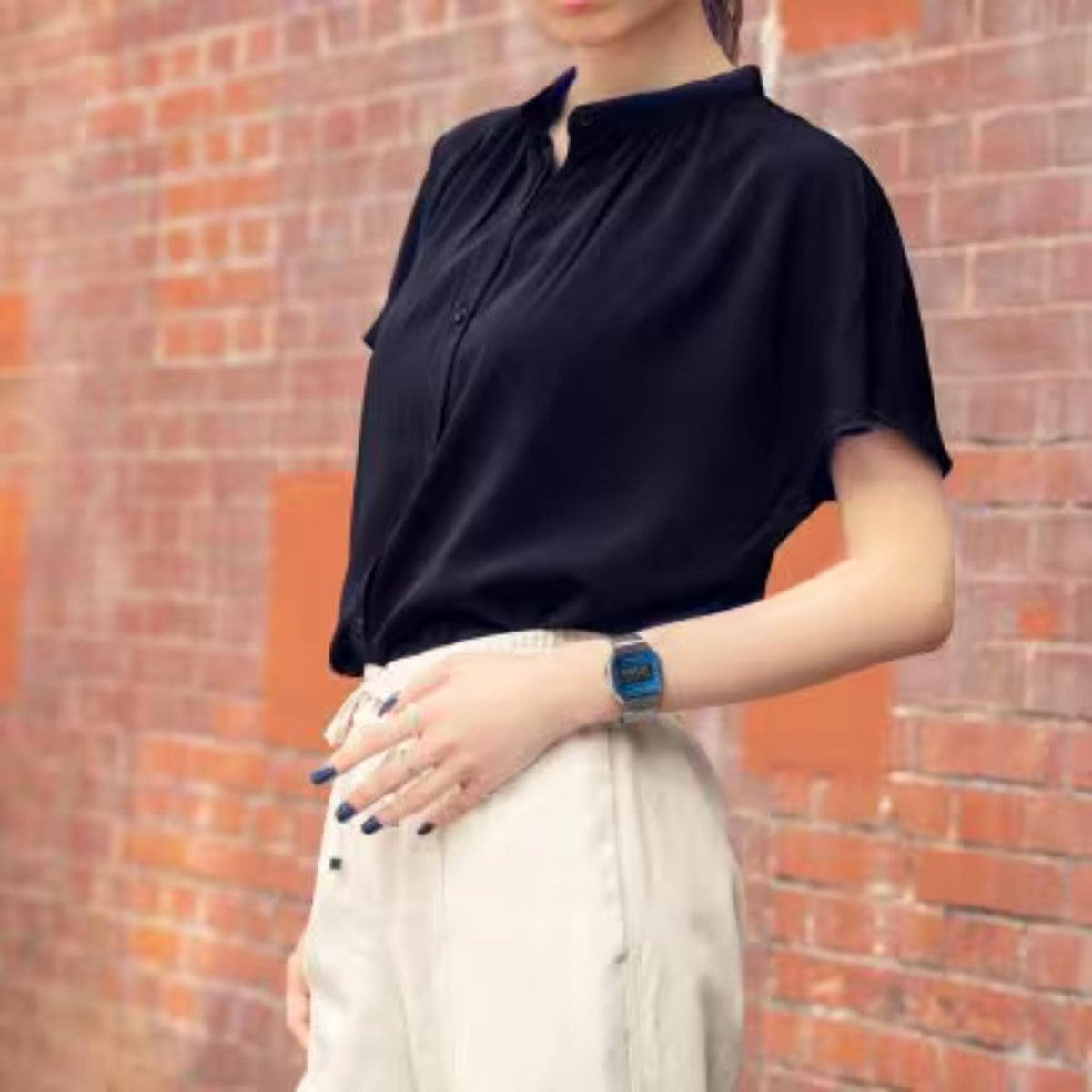 Casio Vintage Iconic A168WEM-2BEF silver digital watch worn on a wrist, paired with a black blouse and white trousers