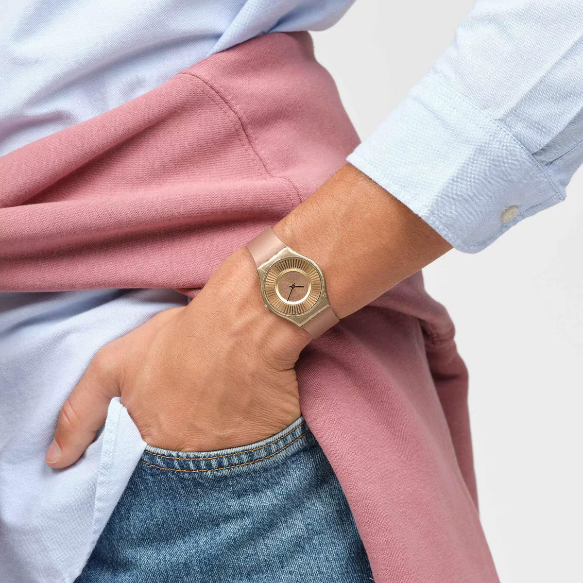 Tawny silicone strap quartz watch with gold-tone round case on wrist