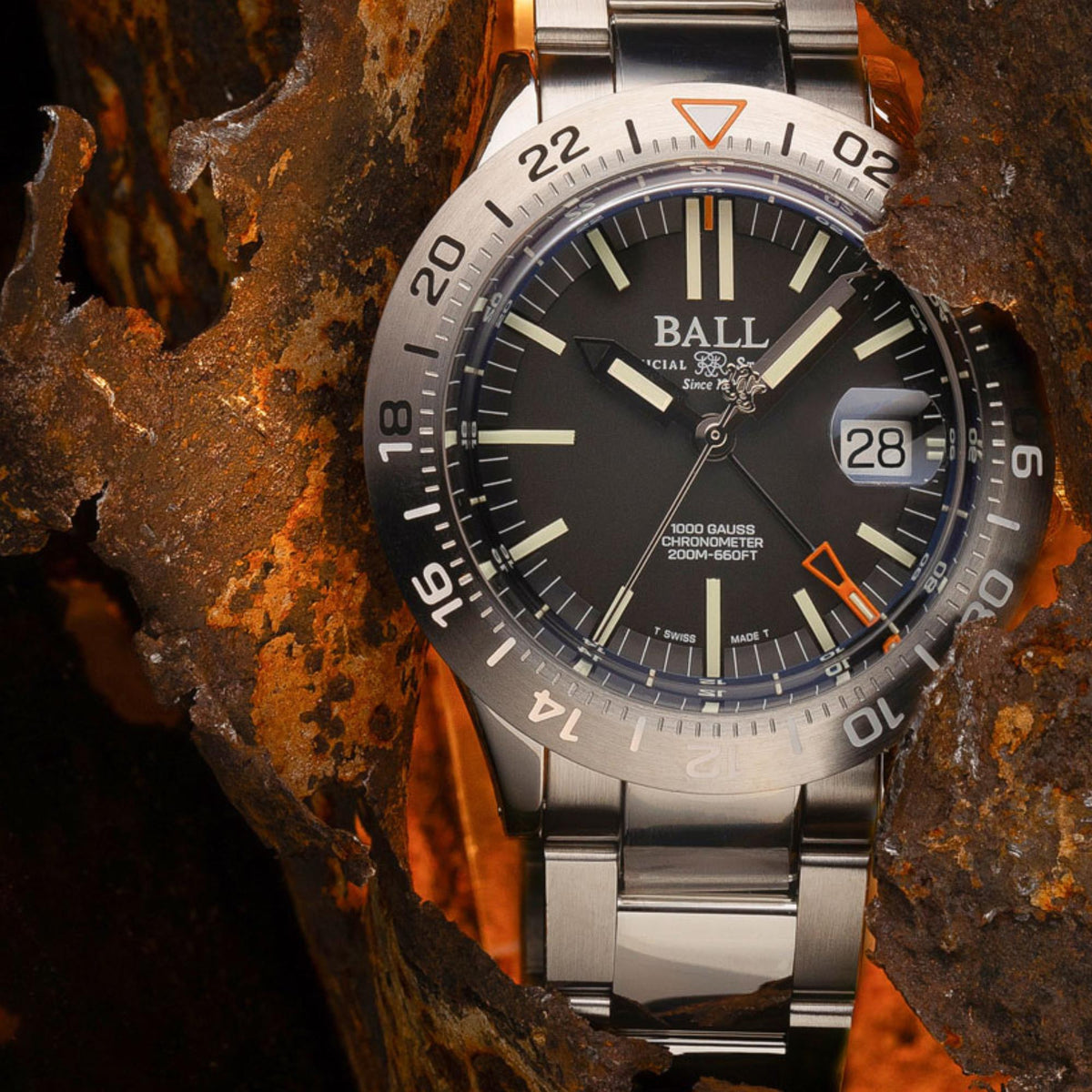 Men's stainless steel wristwatch with dark dial, orange accents, and date window at 28.