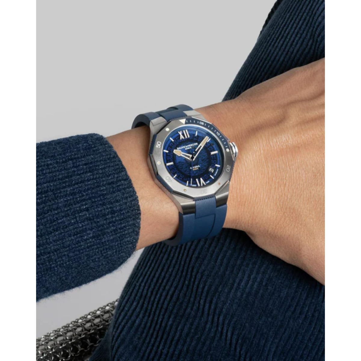 Men's automatic watch on wrist with dark blue dial and blue rubber strap