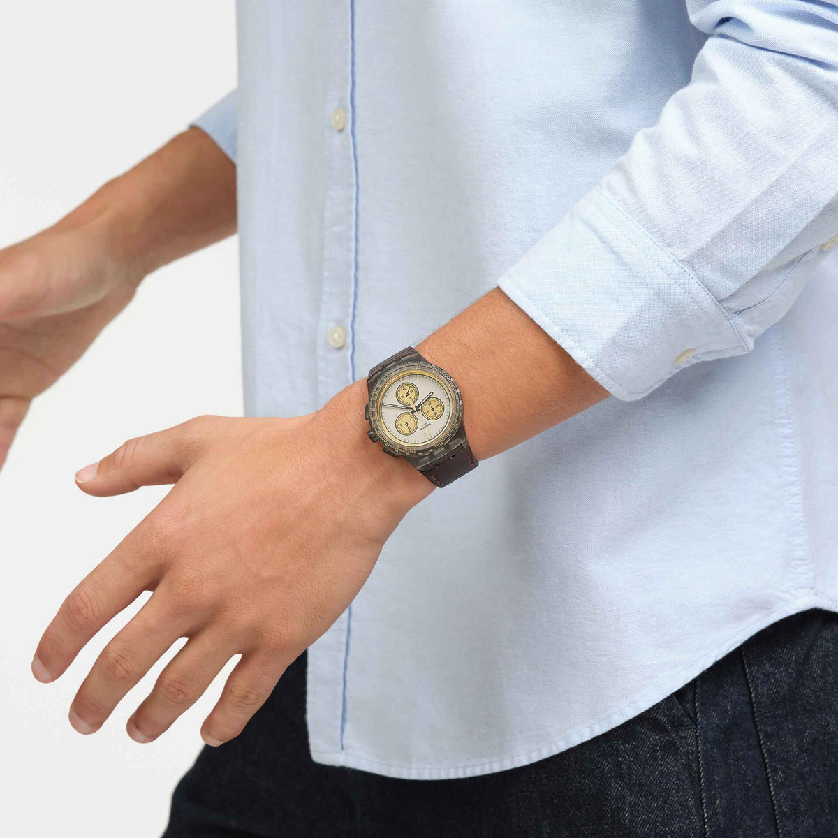 Men's quartz watch on wrist with gold dial and brown leather strap