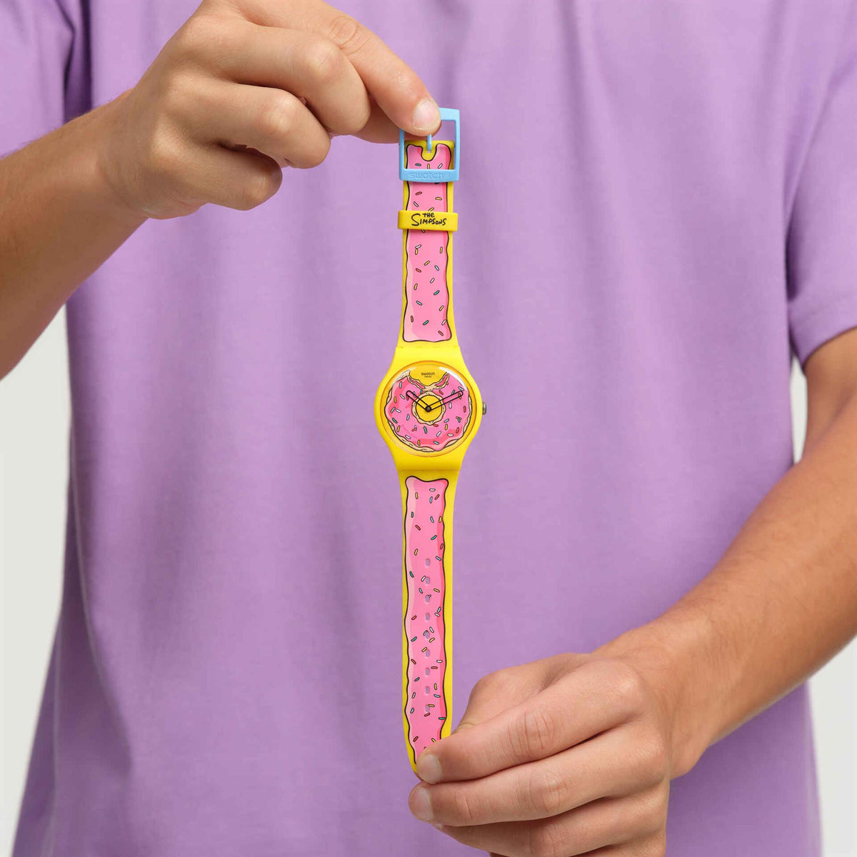 Unisex quartz watch with pink silicone strap and yellow dial, hands shown wearing