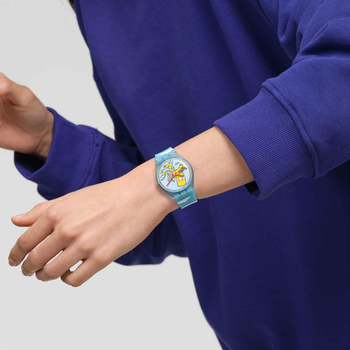 Wrist-worn blue silicone watch with Bart Simpson dial and cloud-printed strap