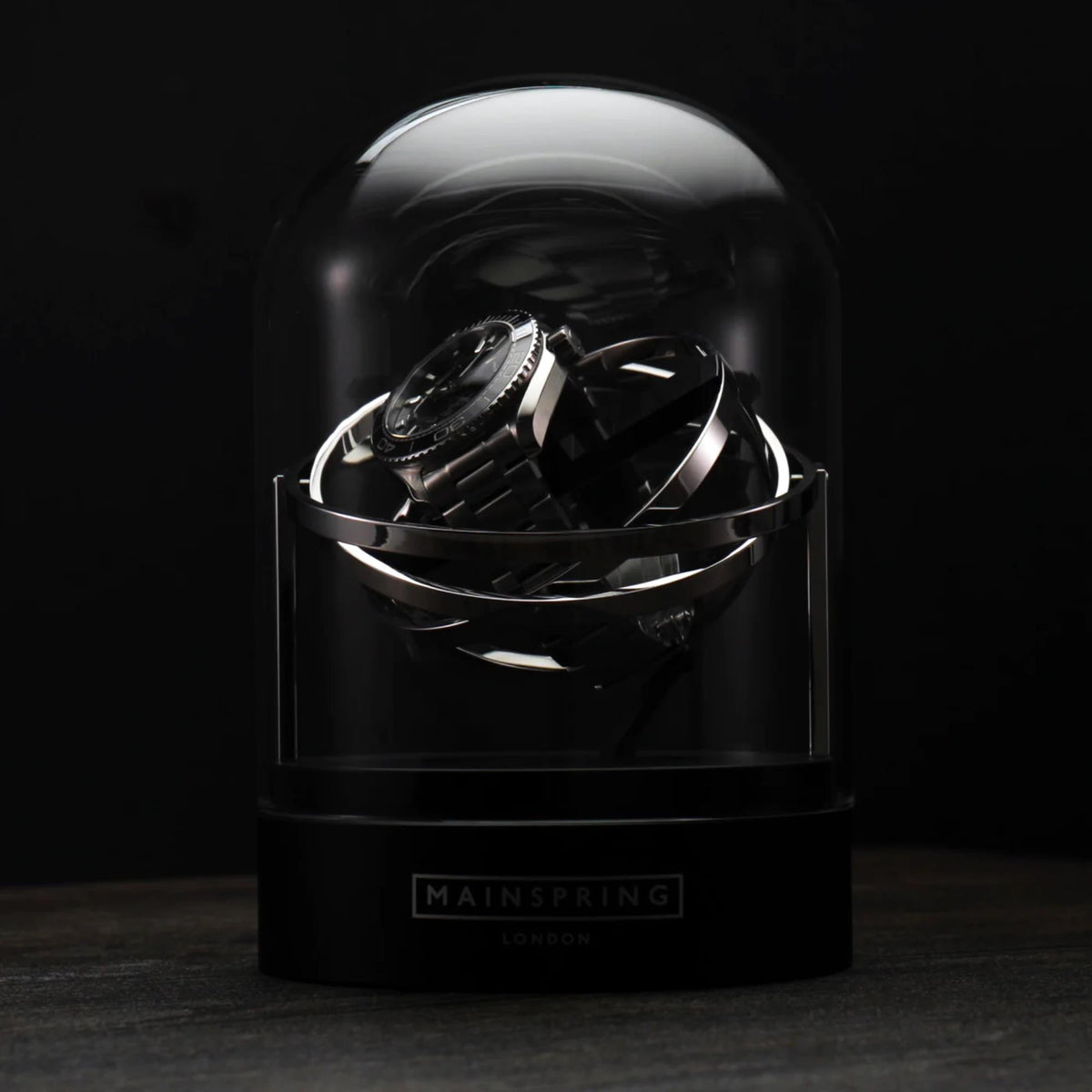 Single-slot watch winder with clear dome and black base, rotating gyroscope rotor
