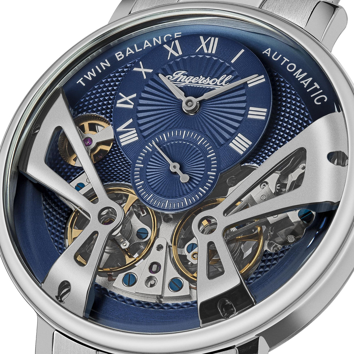 Close-up of blue automatic watch dial with roman numerals, subdials, and gears