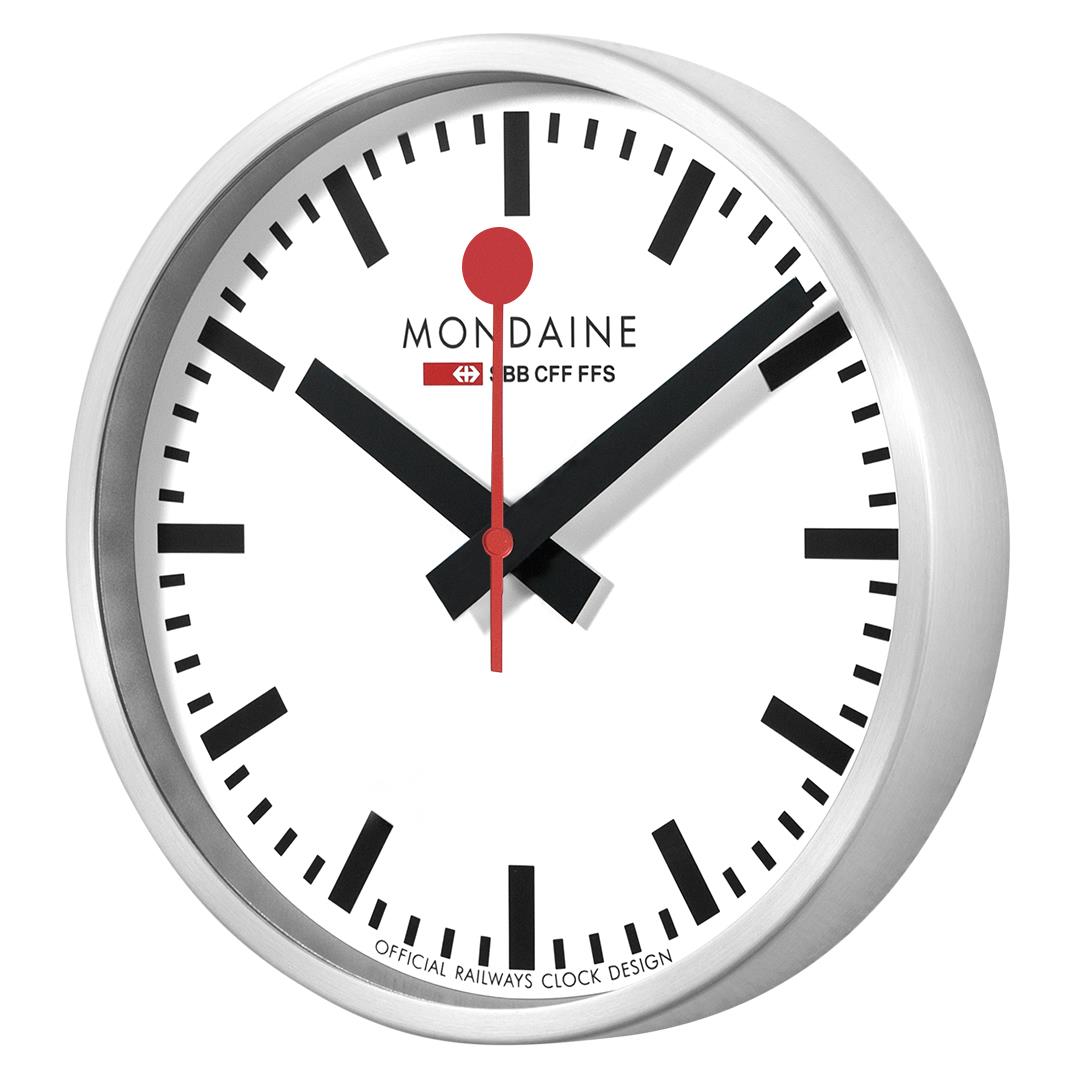 Mondaine wall clock close-up with white dial, black hour markers, and red hands