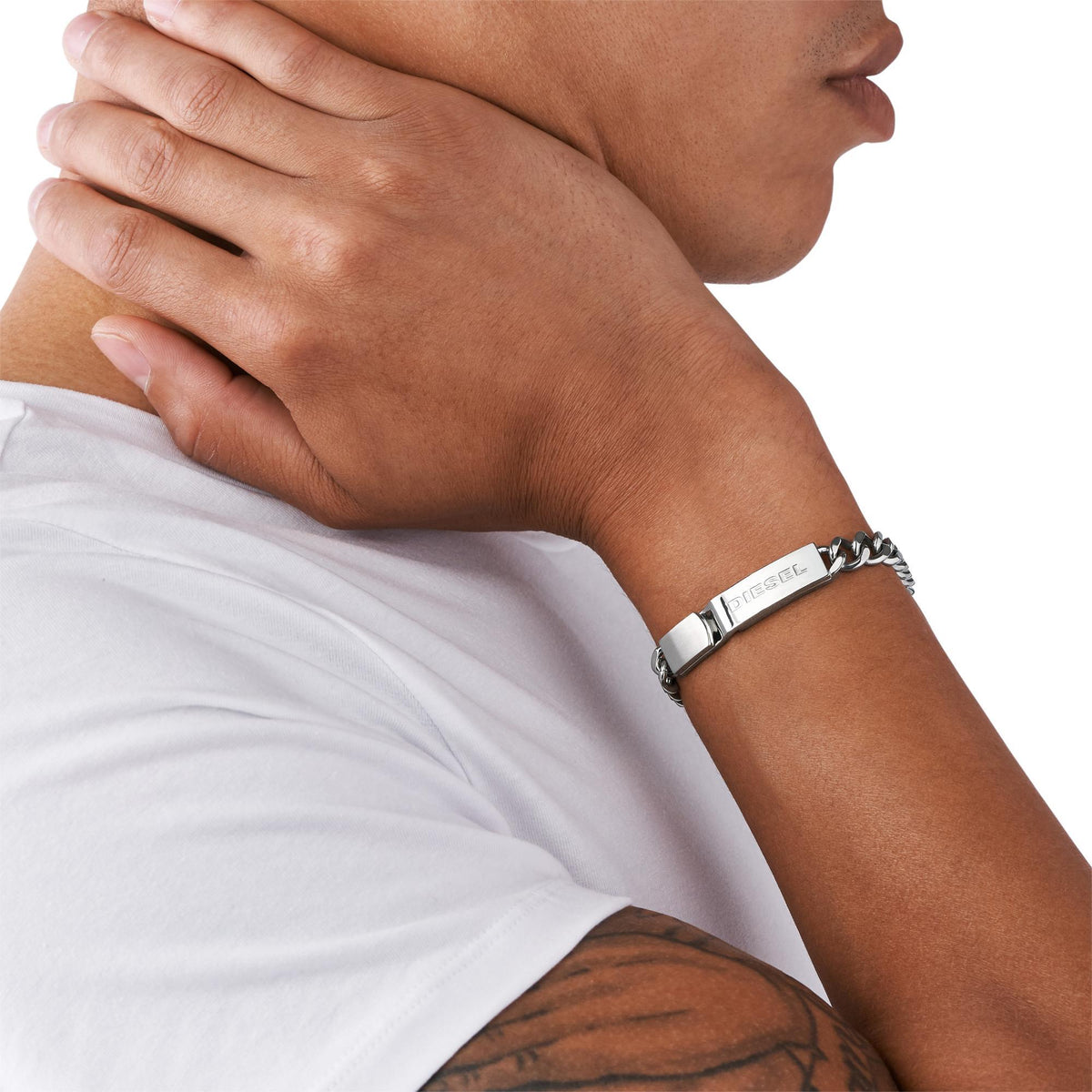 Men's Diesel stainless-steel bracelet on wrist with chain links and logo bar