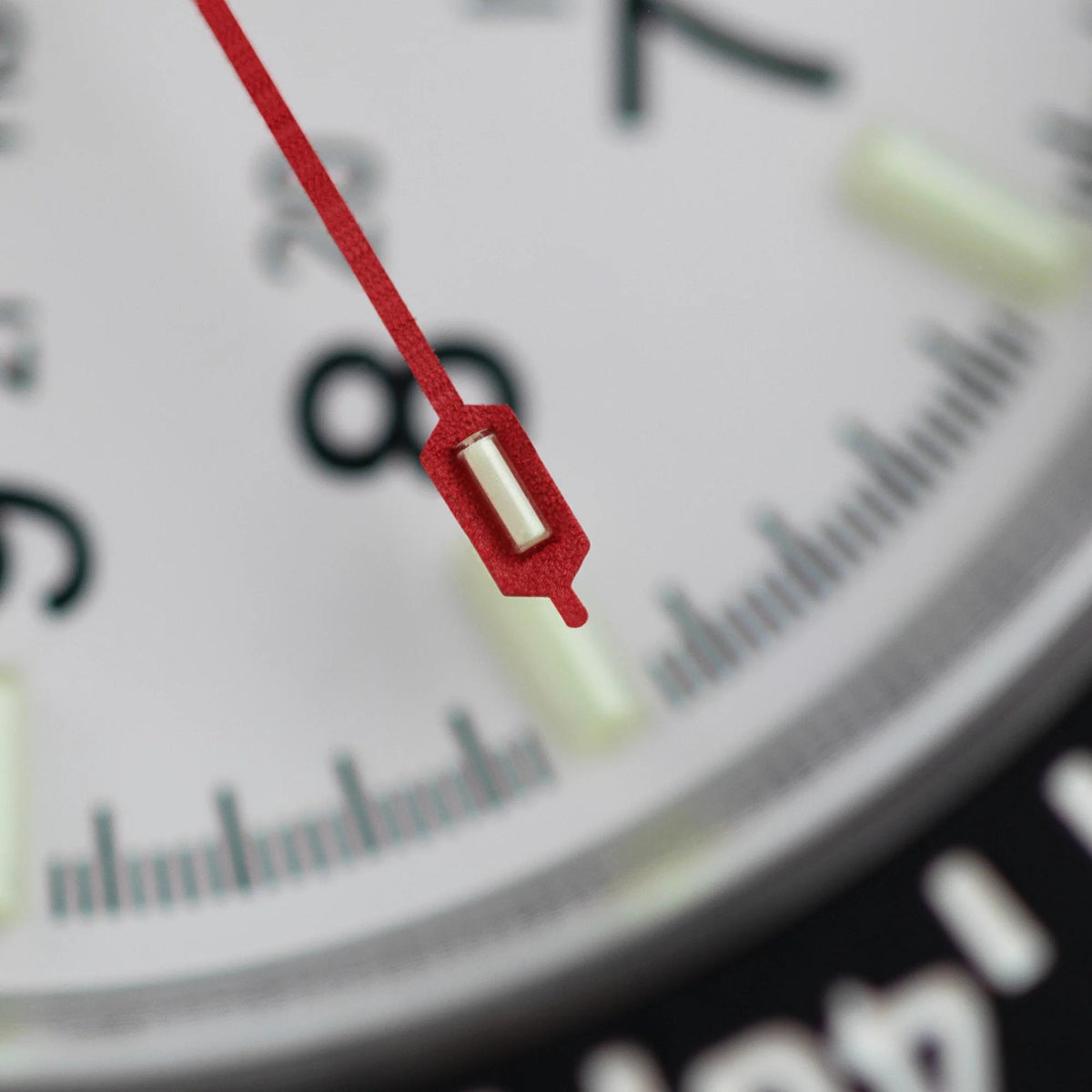 Macro view of diver's watch second hand and minute track on white dial