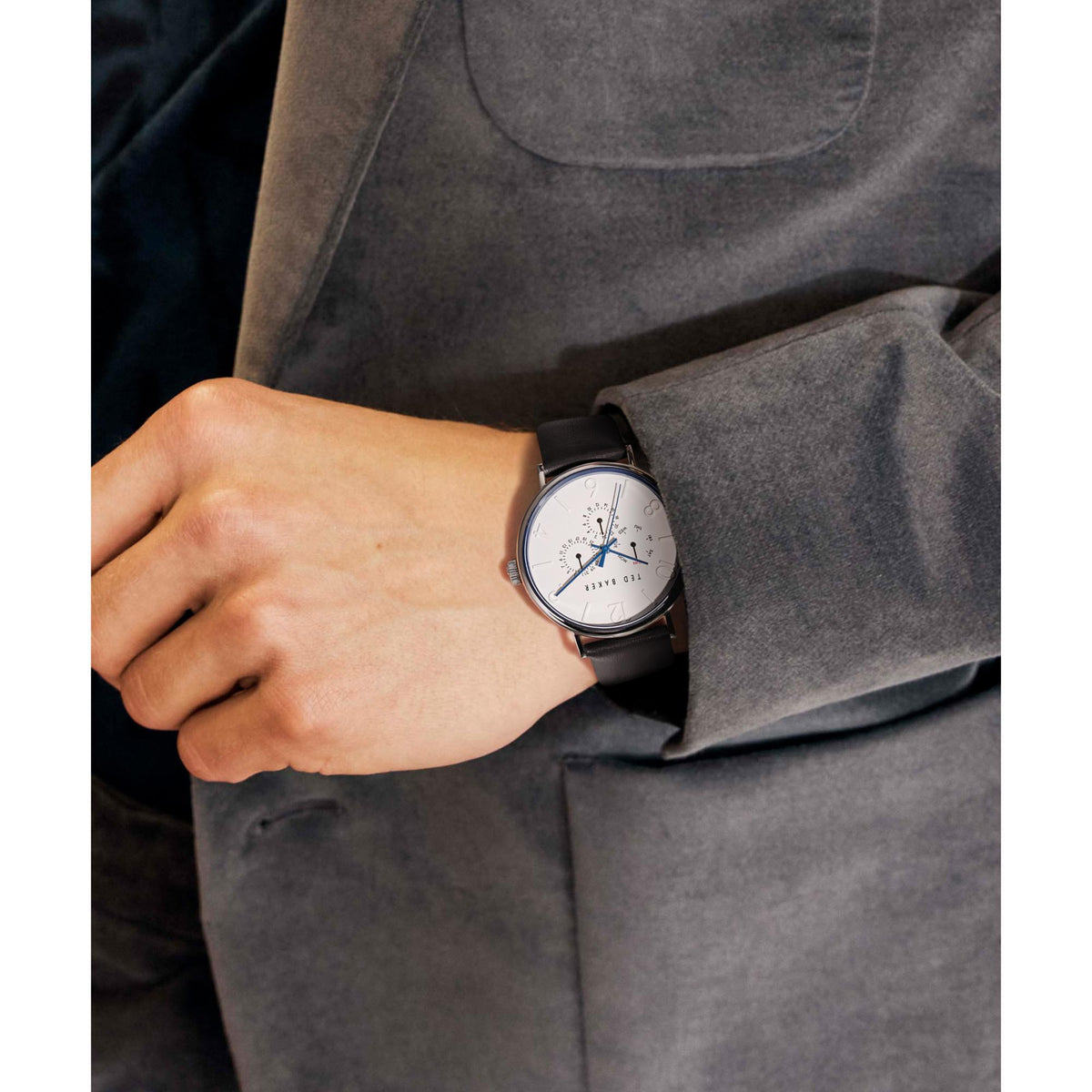 Men's wristwatch on hand, white dial with blue details, black leather strap