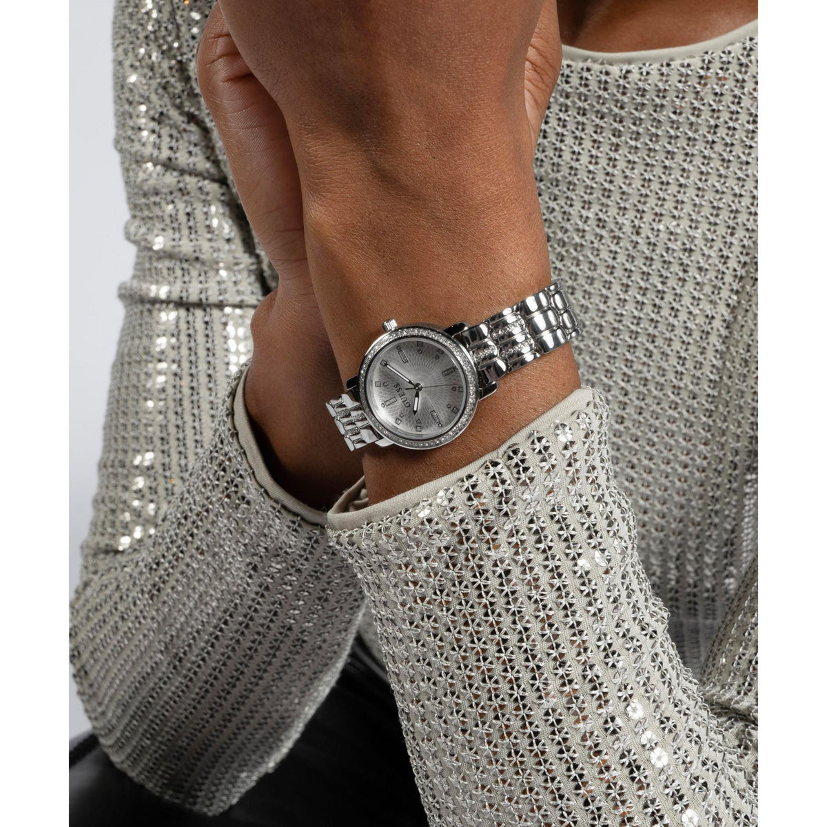 Silver-tone ladies wrist watch with crystal-studded bezel and metal link bracelet.