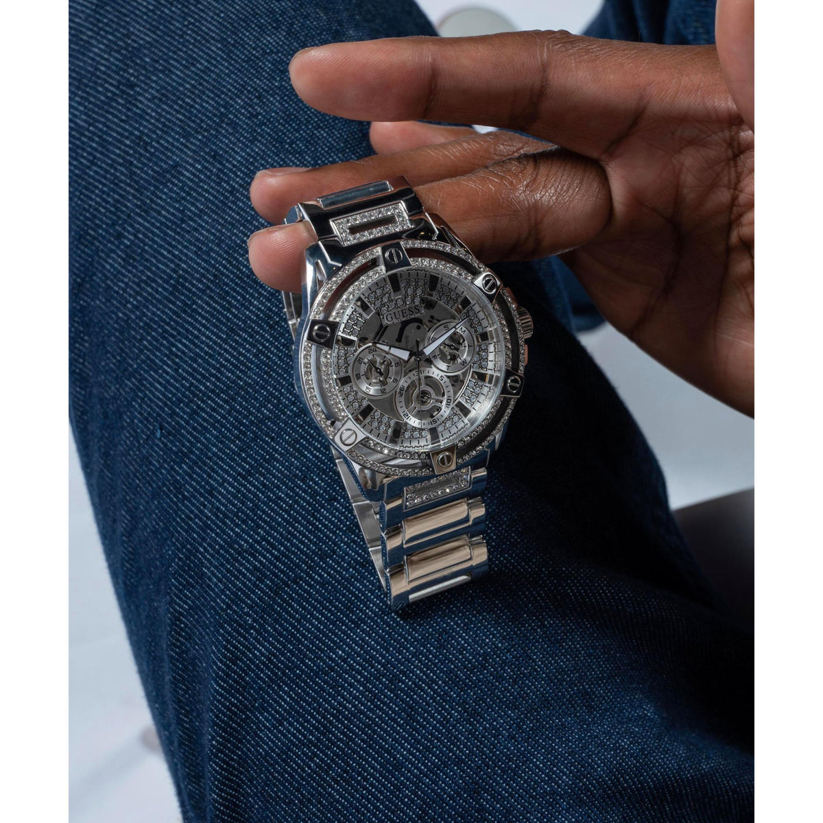 Men’s multifunction watch held in hand with silver crystal dial and stainless steel bracelet