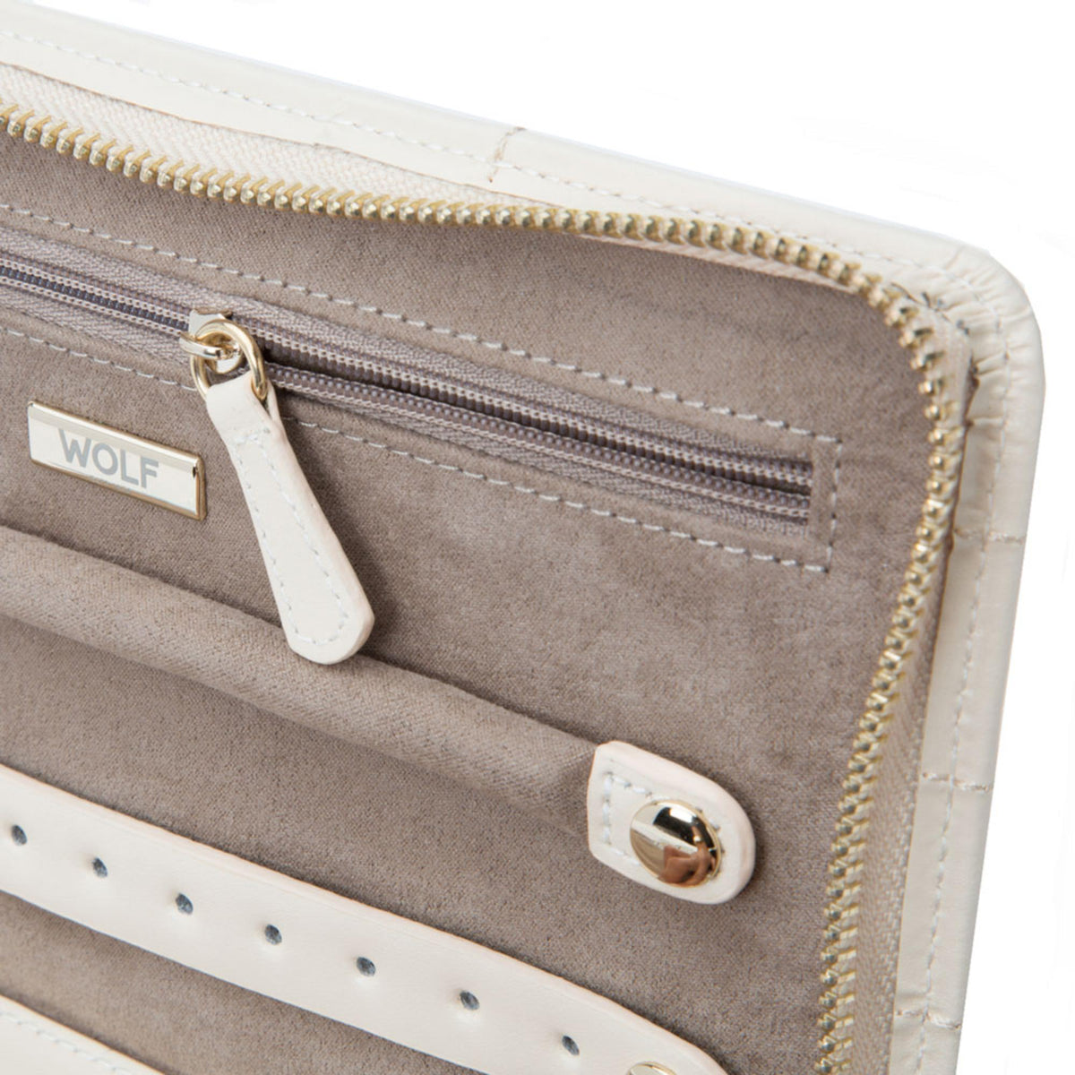 Close-up of beige zip pocket with WOLF tab, ring clasp, and gold zipper