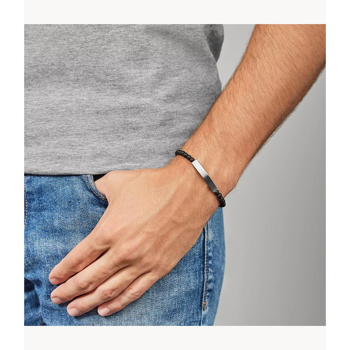 Men's black lava stone bracelet worn, silver plaque across the wrist