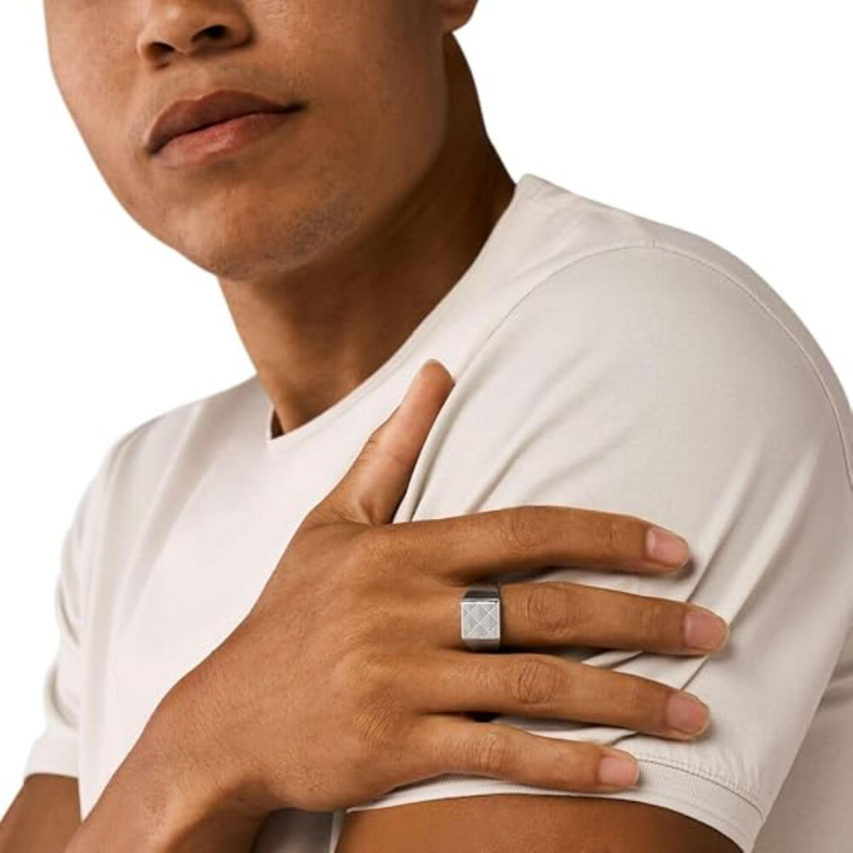 Men's silver signet ring on model's finger, square emblem top