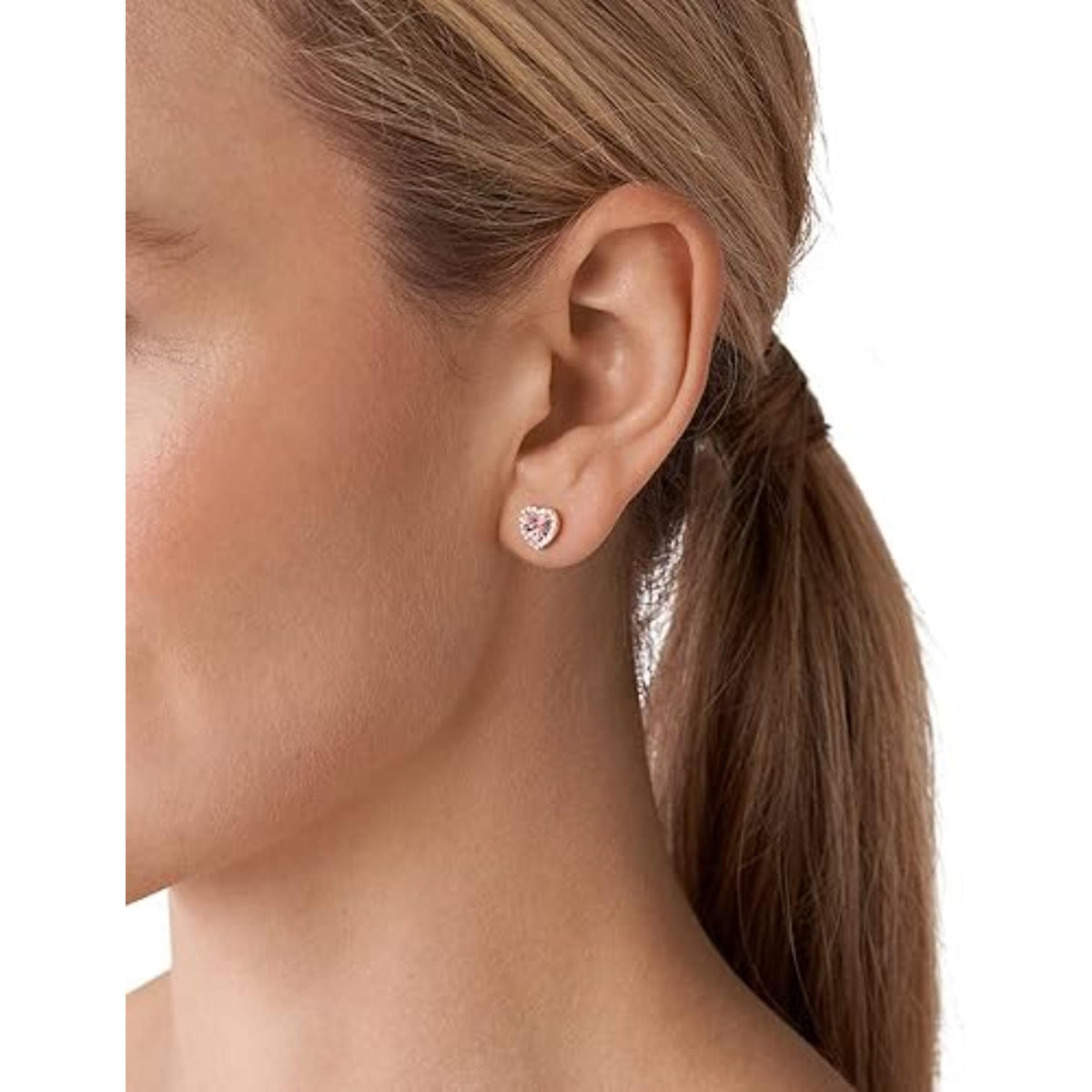 Rose gold heart stud earrings on model ear, faceted pink heart with sparkling white crystals